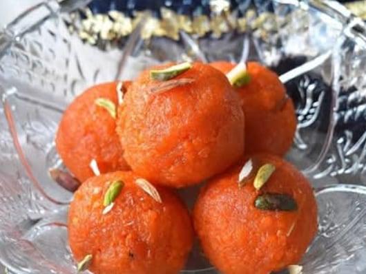 Motichoor laddu piled on a plate, studded with raisins