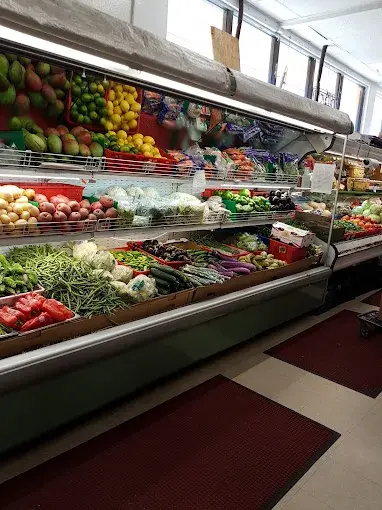 The chilled produce case, stacked with mangoes, tomatoes, potatoes, beans, cucumbers and aubergines